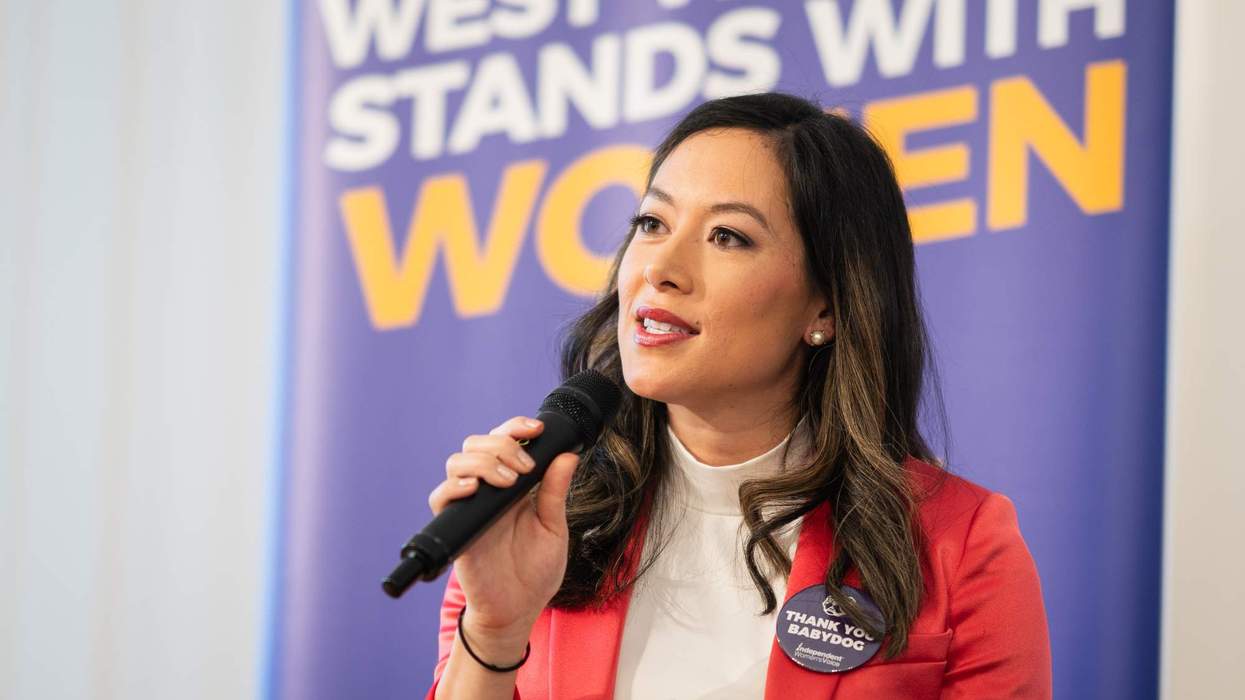 May Mailman seated in front of a poster that reads "West Virginia stands with women."