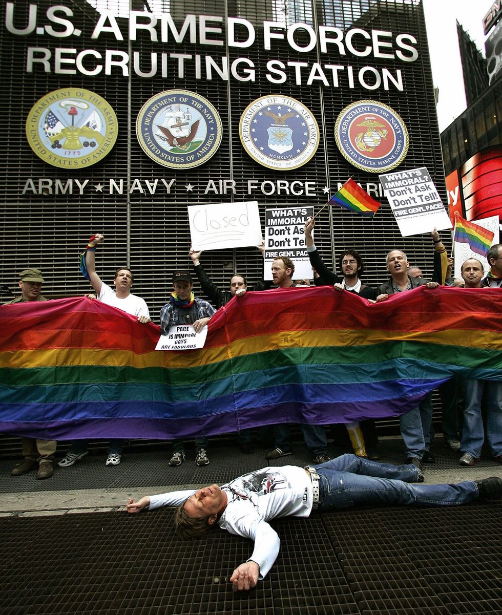 Members of ACT UP AIDS Coaltion to Unleash Power hold out banners and rainbow flags as they demonstrate in New York CITY Times Square Military recruitment center against Dont Ask Dont Tell military policy 2007