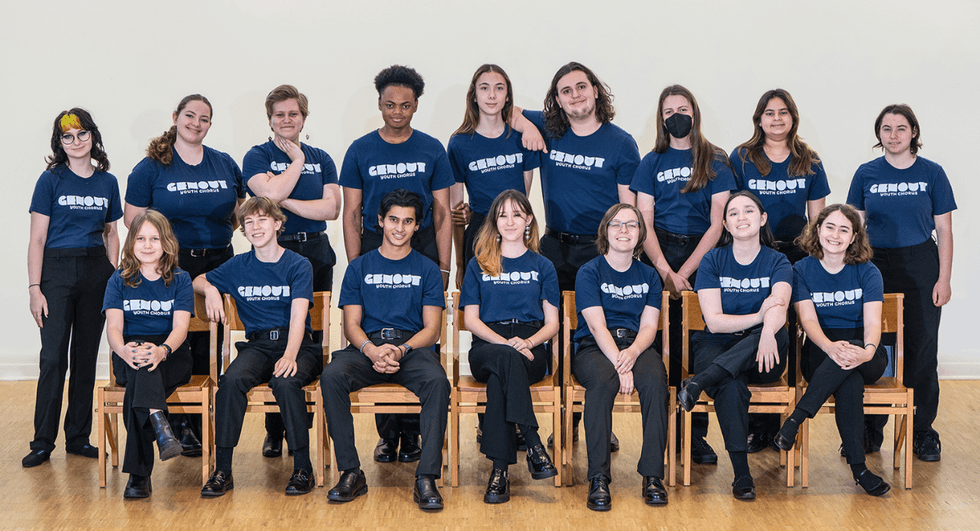 Members of the GenOUT Youth Chorus pose together in matching navy blue shirts