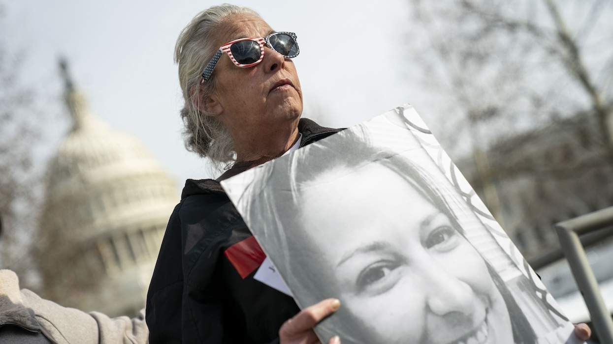 Micki Witthoeft, mother of Ashli Babbitt, holds a photo of Ashli in front of the Capitol building.