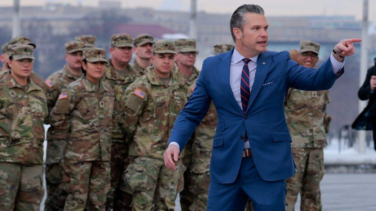 military members in formation behind pete hegseth