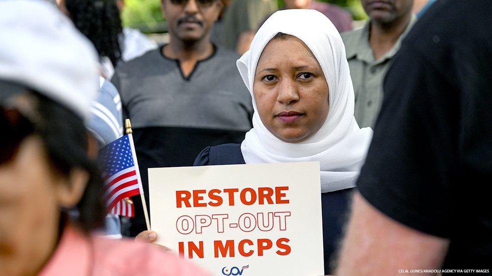 Montgomery County Maryland Parent holding a restore opt-out in MCPS sign