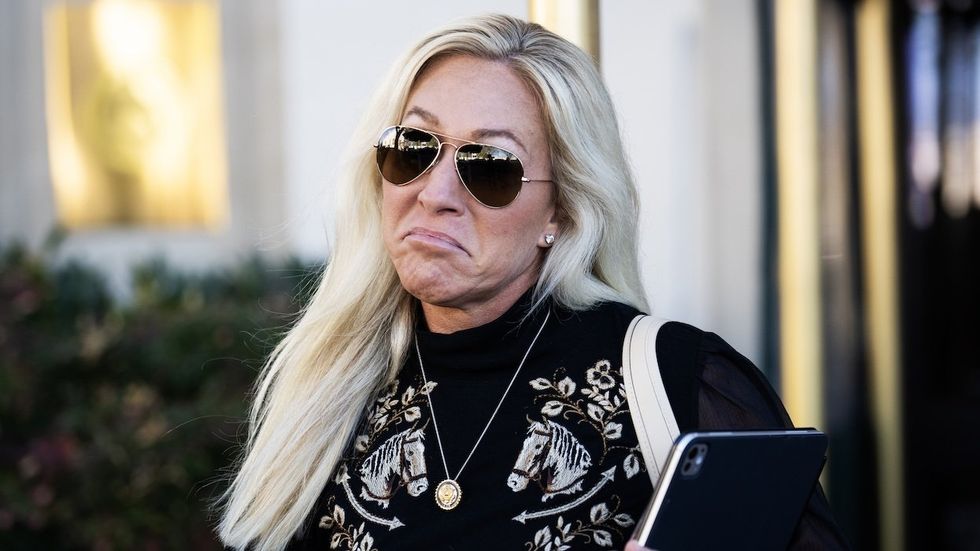 MTG leaving meeting in sunglasses making a frowning face