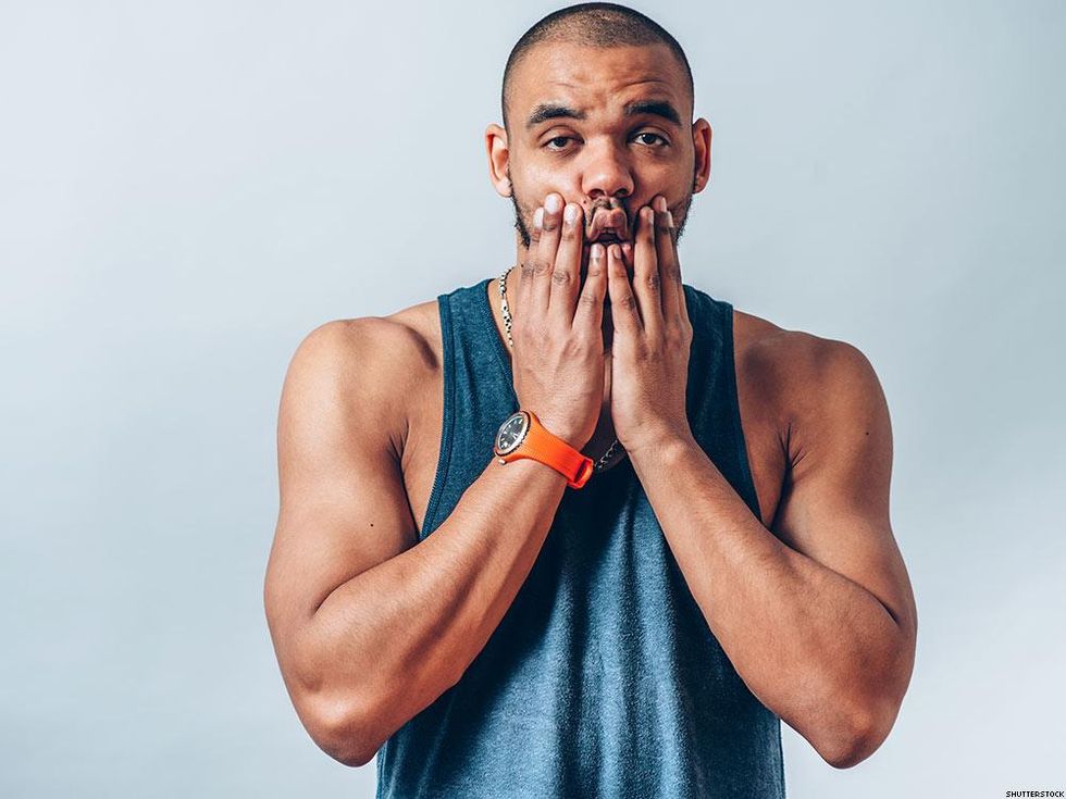 muscle man in tank top with hands over mouth