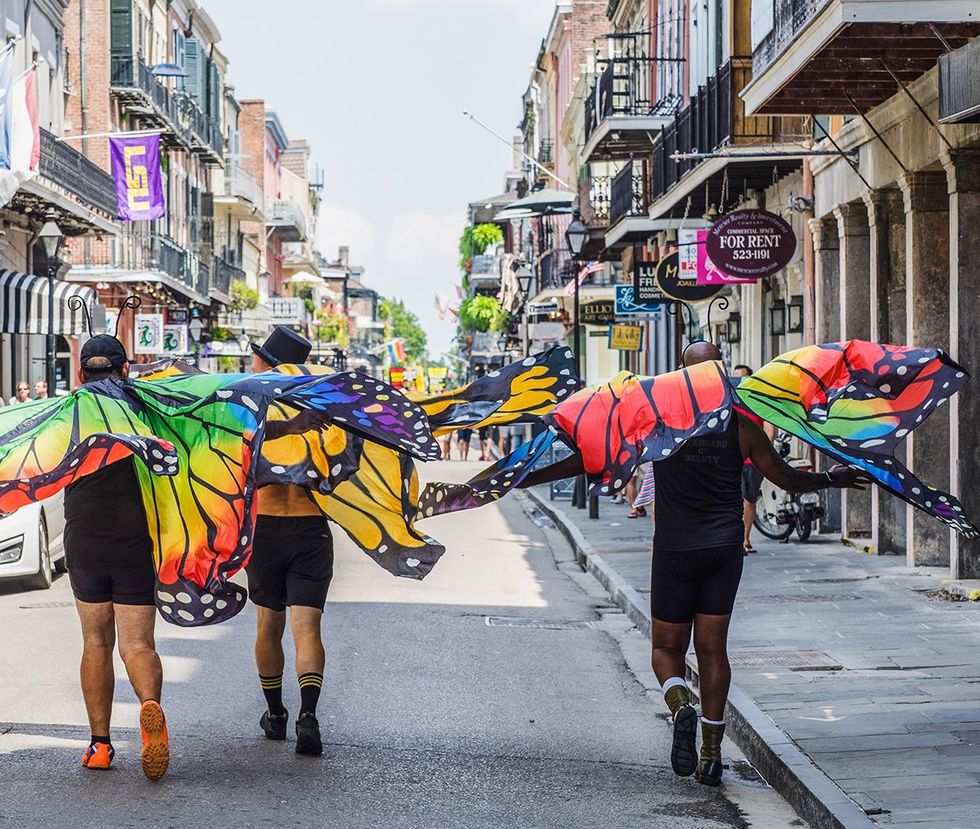 New Orleans Louisiana 2017 three men walking down the street wearing rainbow butterfly wings