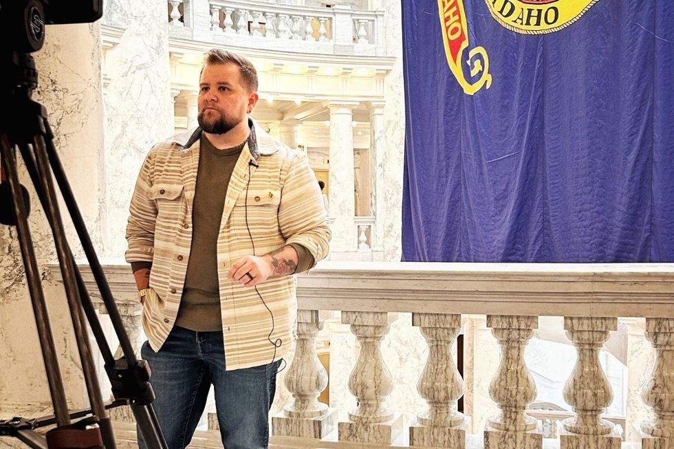 nikson matthews standing on an interior capitol balcony doing a tv news report