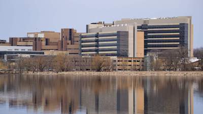 Office buildings sit on the edge of a lake.