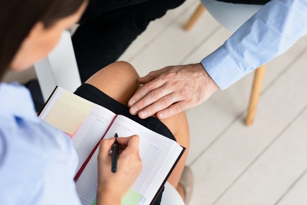 Old hand on young girl's knee