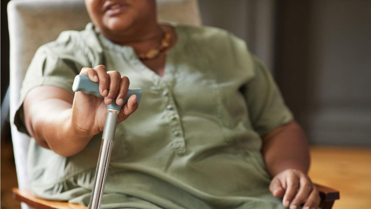 older woman in a chair holding a cane