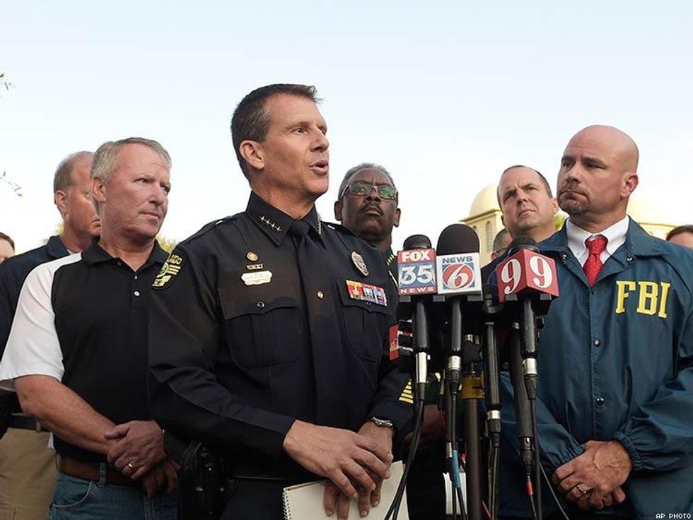 Orlando Police Chief John Mina, center, addresses reporters during a news conference