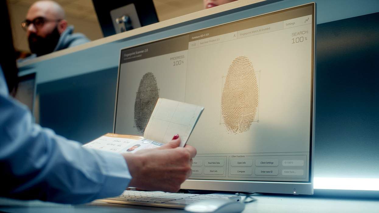 passport agent at USA customs checkpoint reviewing travel documents in front of a computer screen