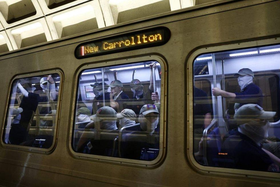 patriot front members riding a metro train to new carrollton