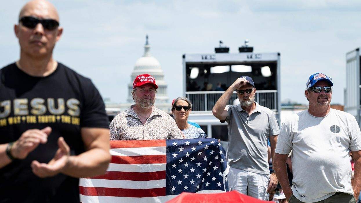 people at a prayer service with a make america great again hat