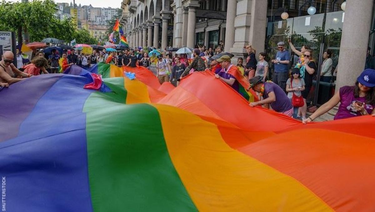 People holding a giant rainbow flag