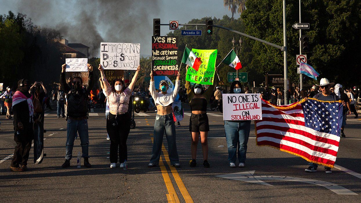 people holding signs and flags during a protest against the immigration raids conducted by ICE and Federal police in Los Angeles June 9th 2025