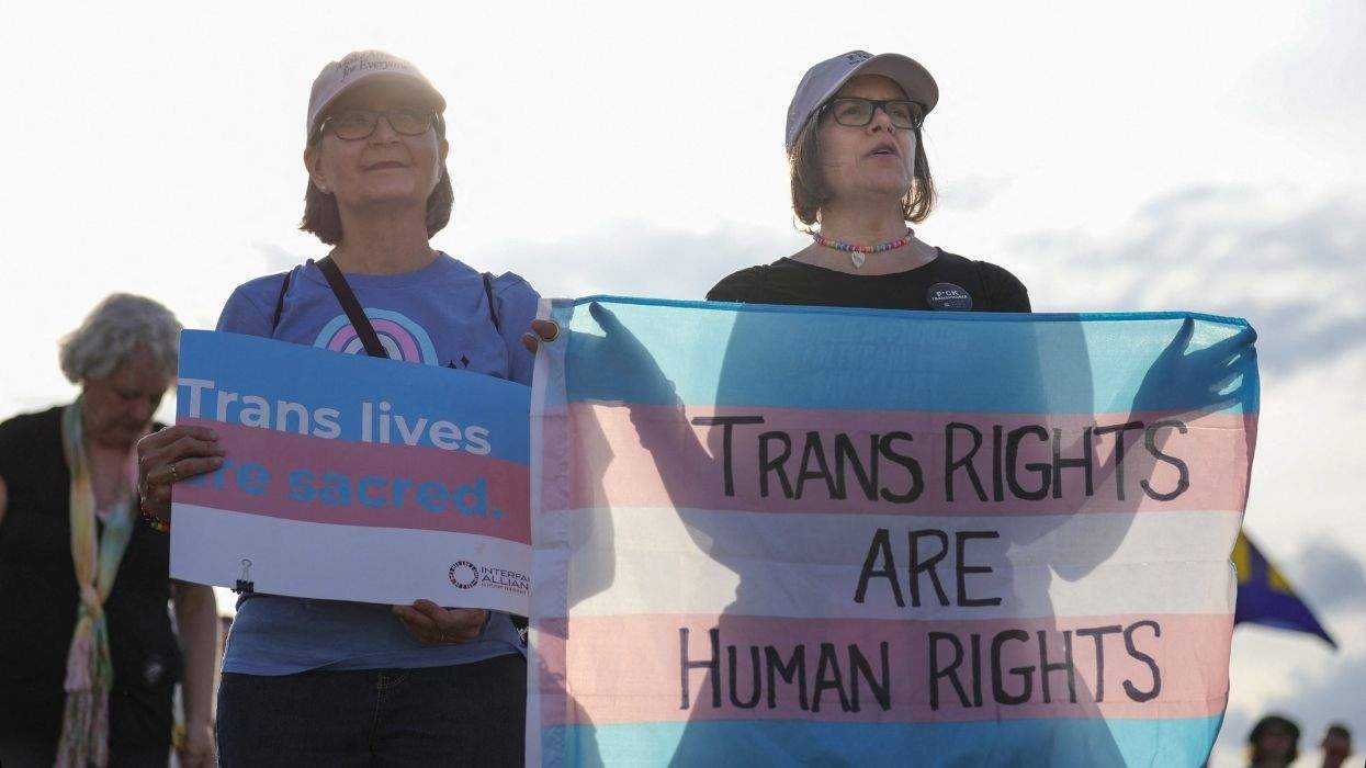people holding trans rights are huan rights and trans lives are sacred signs