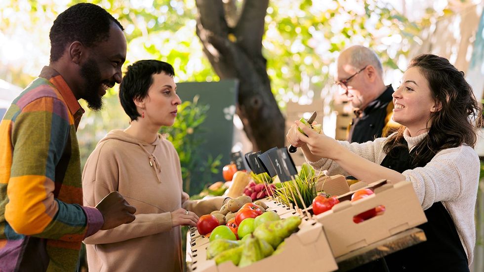 people interacting at farmers market stand