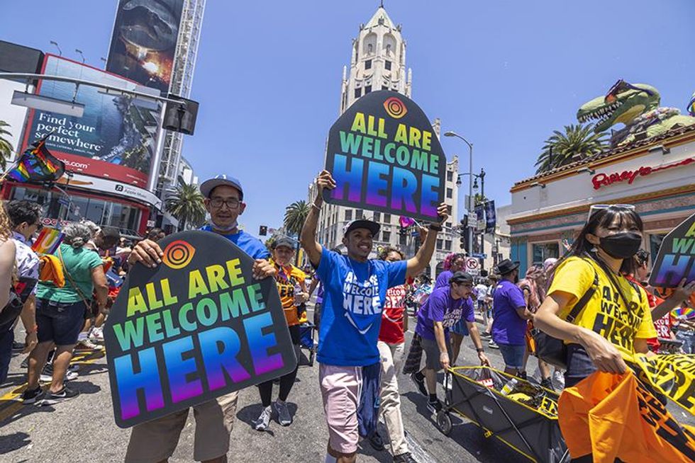 People march through the landmark intersection of Hollywood and Highland during the annual Pride Parade on June 12, 2022 in the Hollywood section of Los Angeles, California. The event returns after a two-year hiatus due to the COVID-19 pandemic.