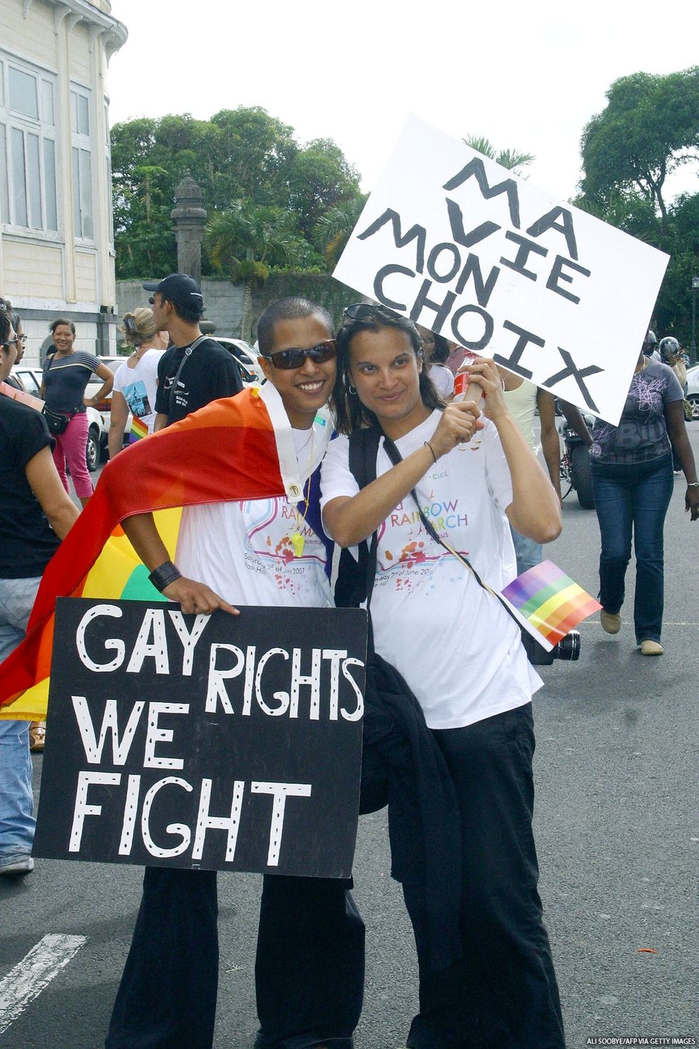 People standing in the street with signs protesting for gay rights