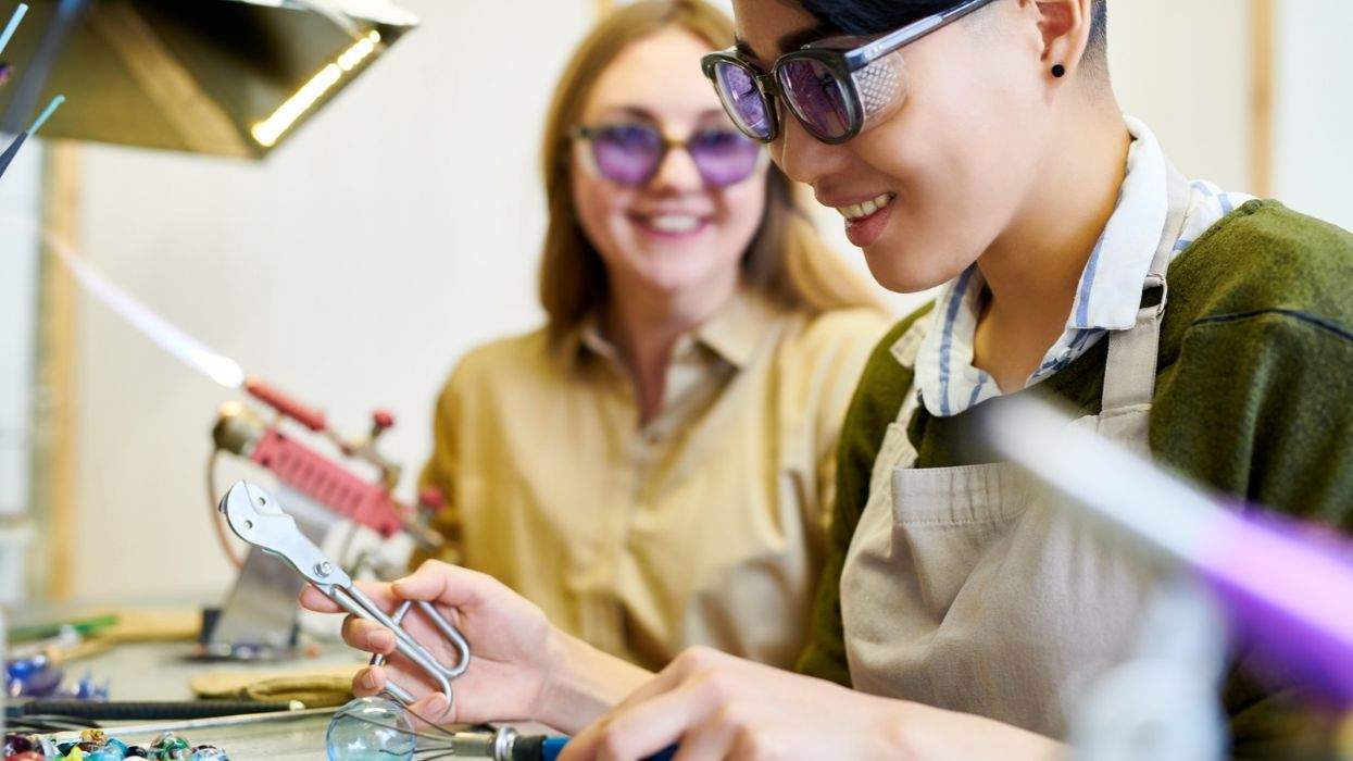 people using tools to shape glass