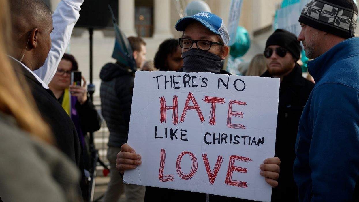 person holding a sign in front of the u.s. supreme court that reads there's no hate like christian love