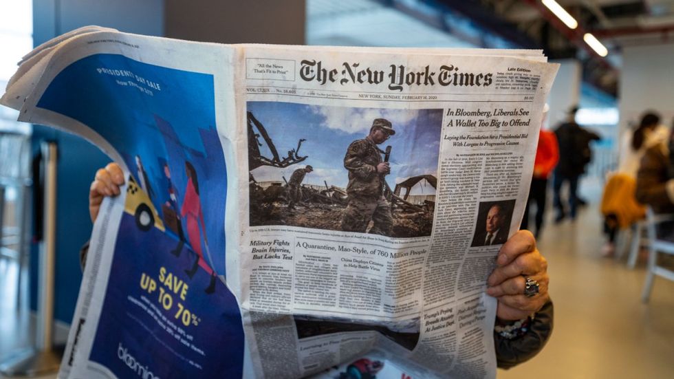 Person holding copy of New York Times