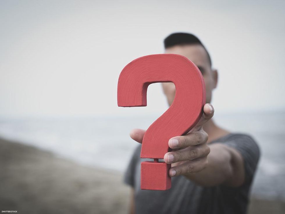 person holding out a question mark sculpture