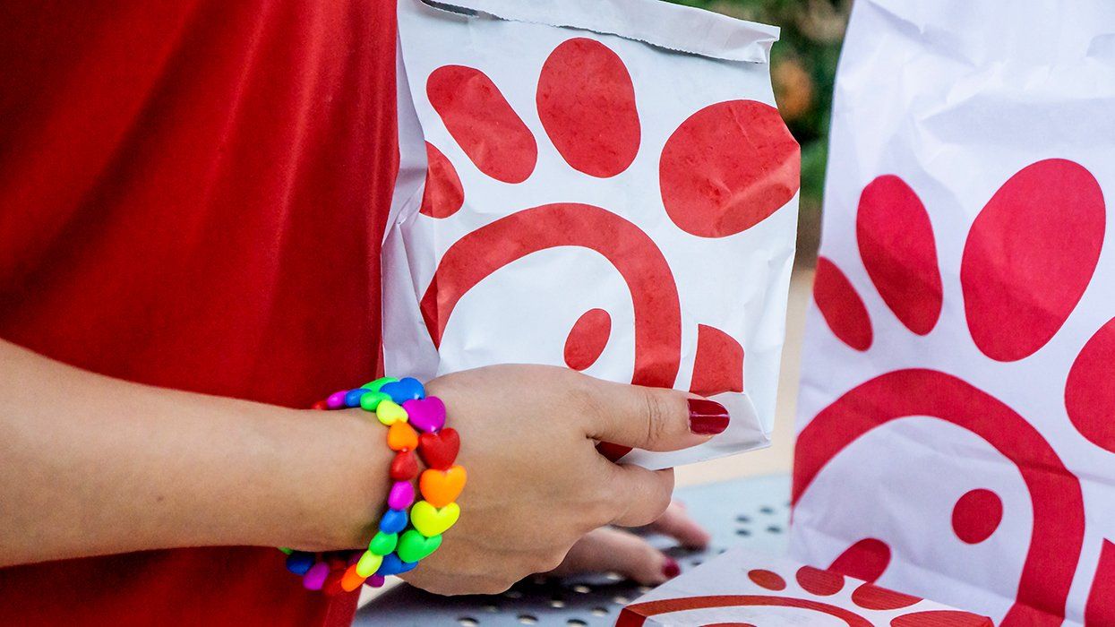 person with rainbow bracelet holding chicfila fast food packages