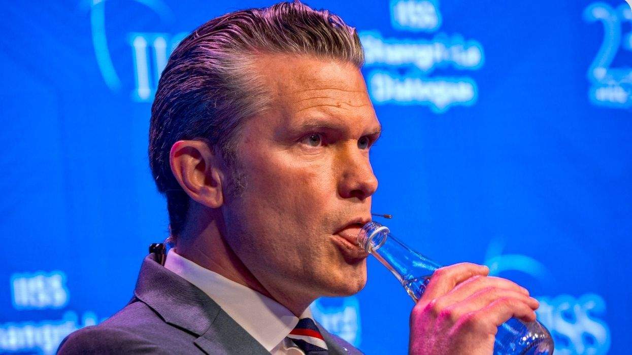 pete hegseth drinking water at an event where he's onstage speaking