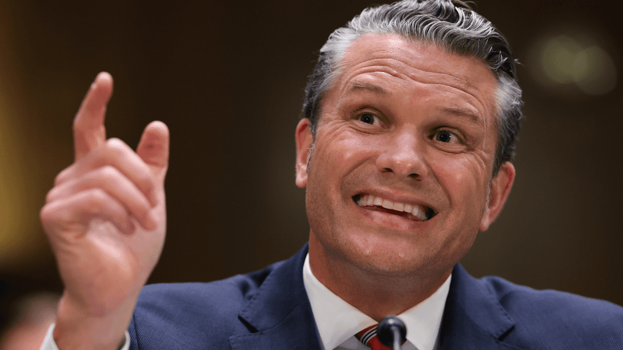 Pete Hegseth smiles and gestures while testifying at a congressional hearing.