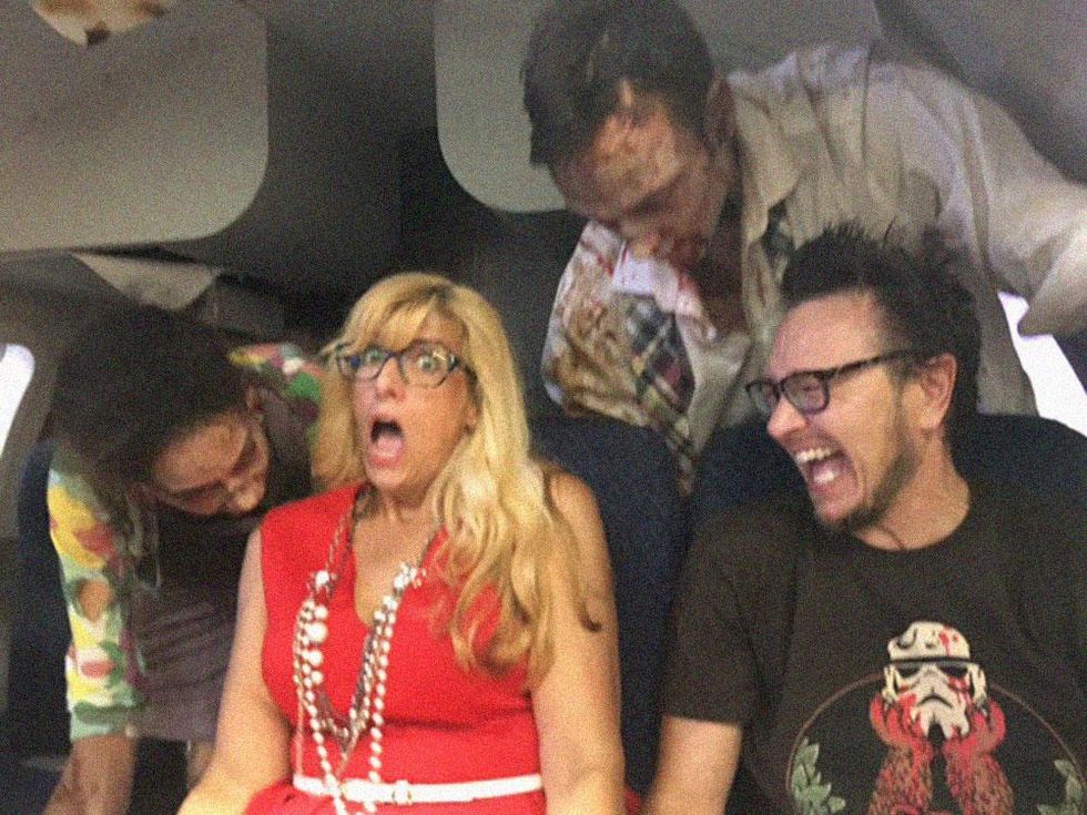 Plus magazine Editor in Chief Diane Anderson-Minshall and Senior Editor Jacob Anderson-Minshall attacked by zombies in the Ash vs The Evil Dead booth.