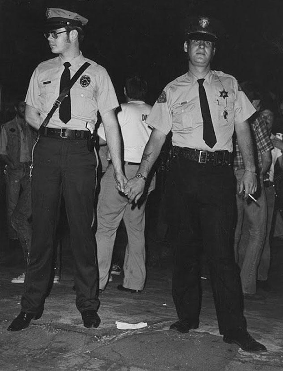 Police officers holding hands at the Los Angeles Christopher Street West pride parade, 1972