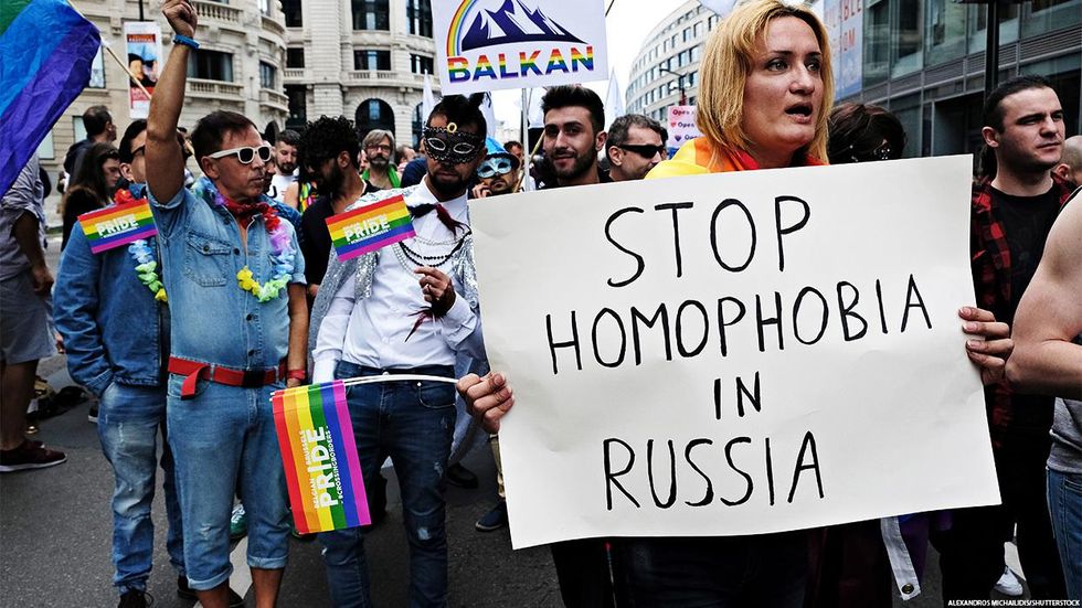 Protest against anti-LGBTQ+ laws in Russia with a person holding a sign that reads "Stop homophobia in Russia"