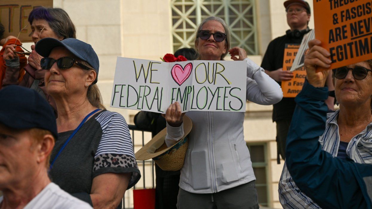 Protester with placard that says "We (heart) our federal employees."