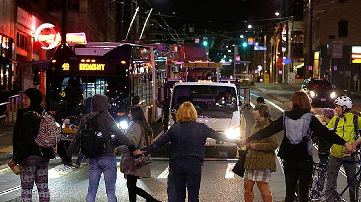 Protesters block a street and stop traffic during a demonstration against President-elect Donald Trump in Seattle.