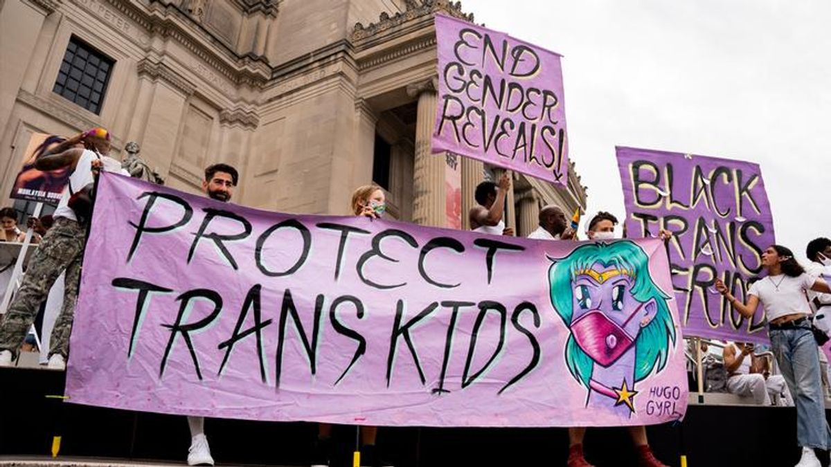 Protesters hold up sign that reads "Protect Trans Kids"