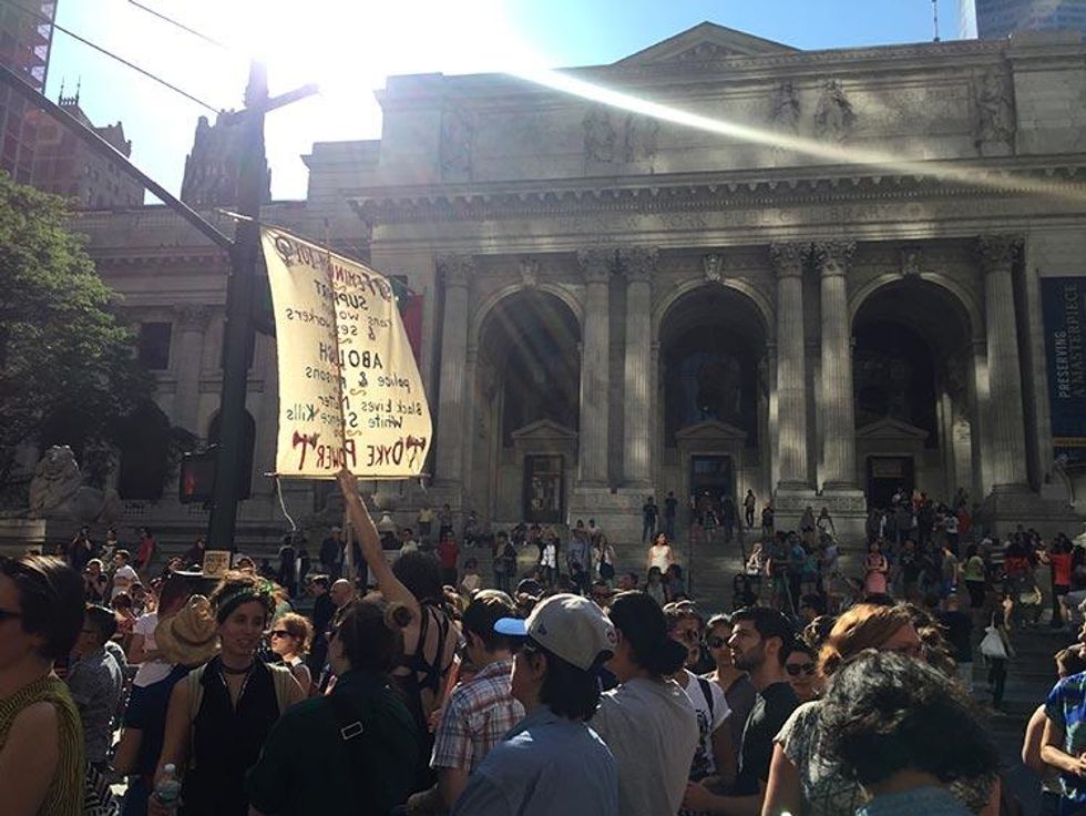 Protesters march past the main branch of the New York Public Library.