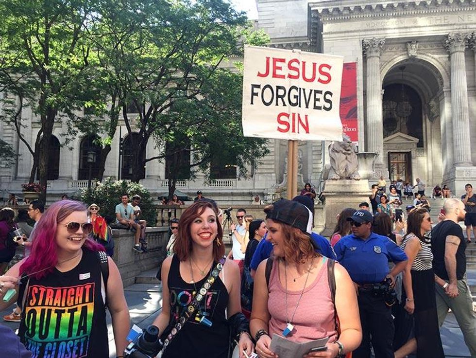 Protesters snap a pic in front of counterprotesters who lined the march route, both silent and shouting.
