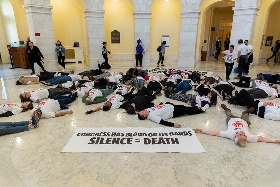 Protesters stage a die-in inside the rotunda of the Cannon House Office Building as part of a protest against cuts to foreign aid, in Washington, D.C., on February 26, 2025.