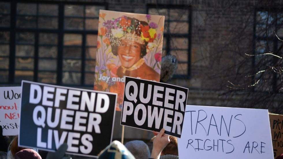 queer power, defend queer lives and trans rights are signs