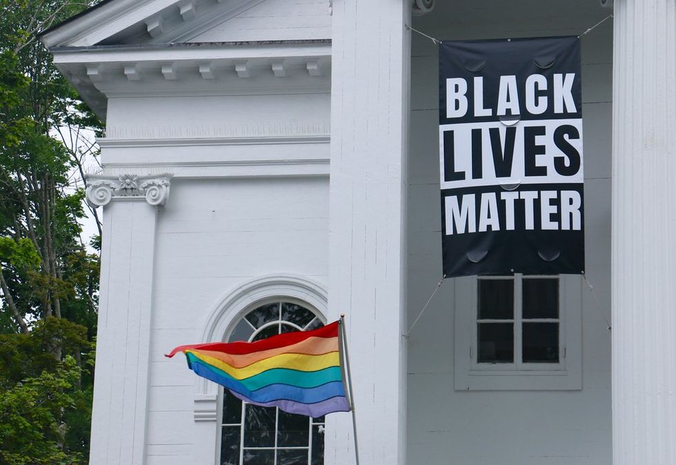 Rainbow LGBTQ+ Pride flag and Black Lives Matter flag outside church