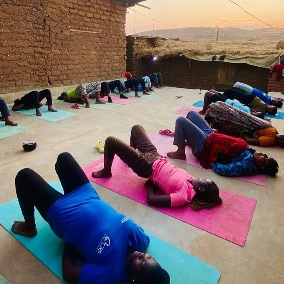 refugees practicing yoga at Dzaleka Refugee Camp in Malawi
