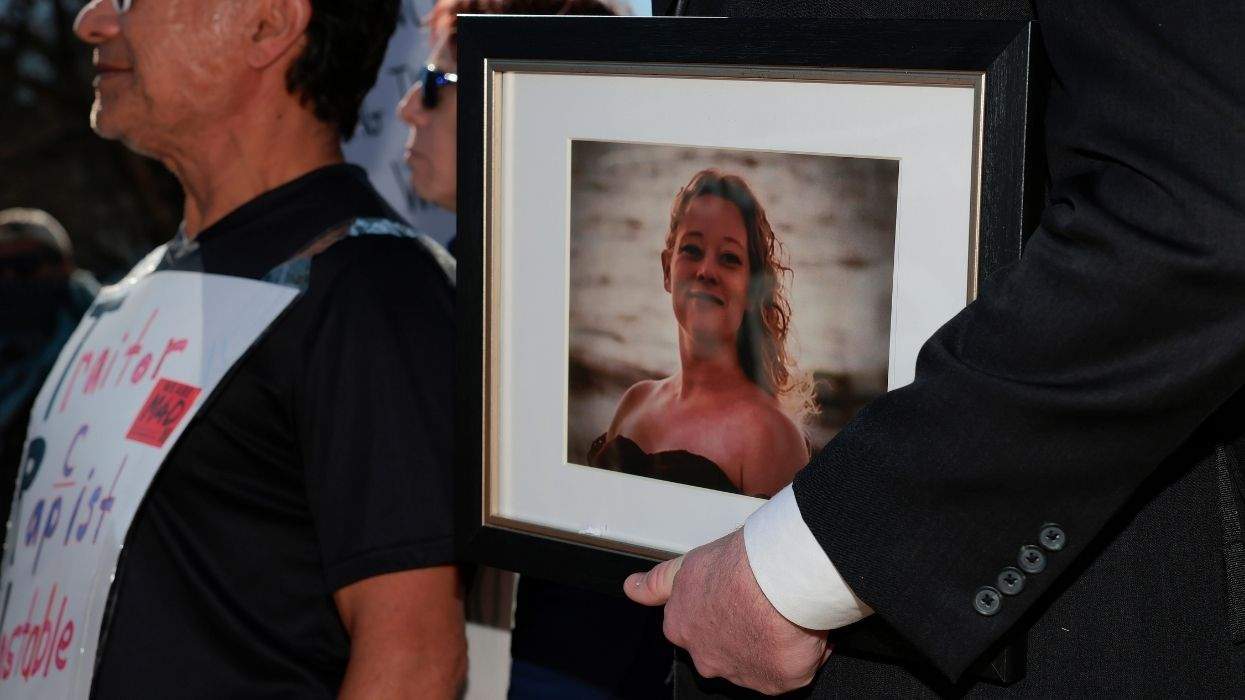 renee good photo held in a frame by a protester