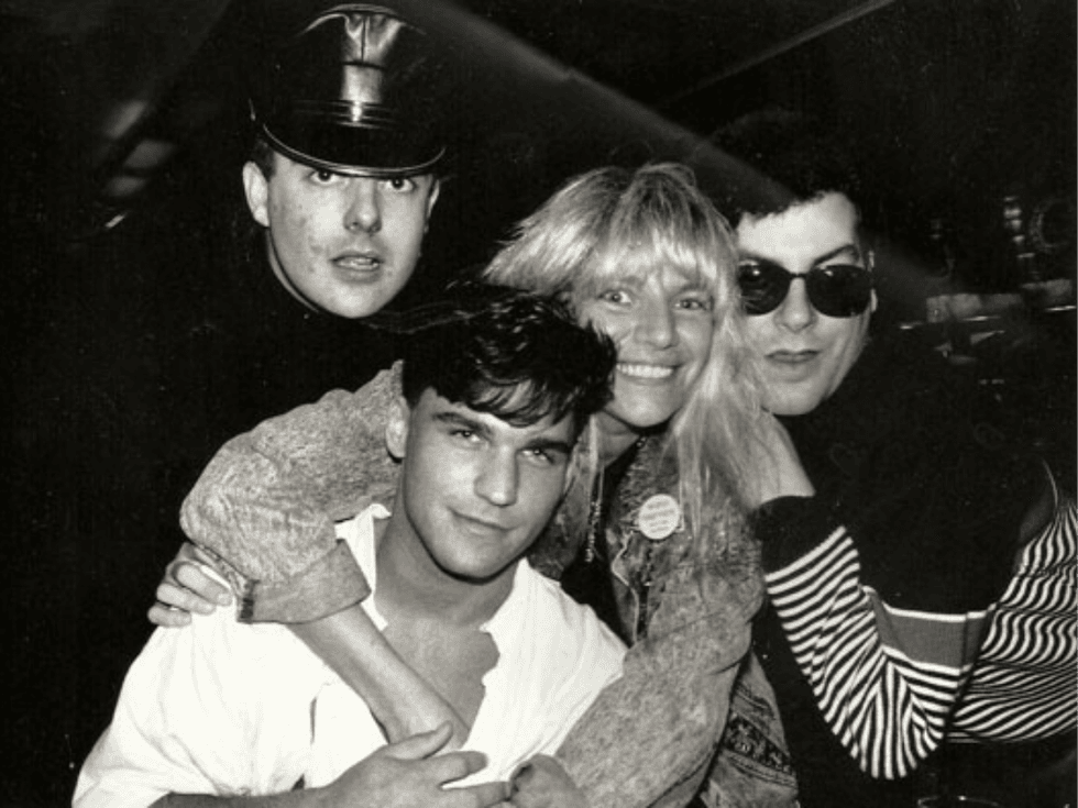 Robin Byrd smiles while posing with three friends in a black and white photograph