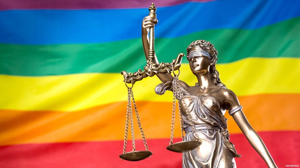 Scales, blind Justice and a rainbow Pride flag.