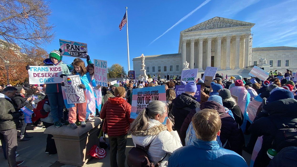 SCOTUS Protest crowd and signs protect trans kids transgender advocates during Skrmetti opening arguments