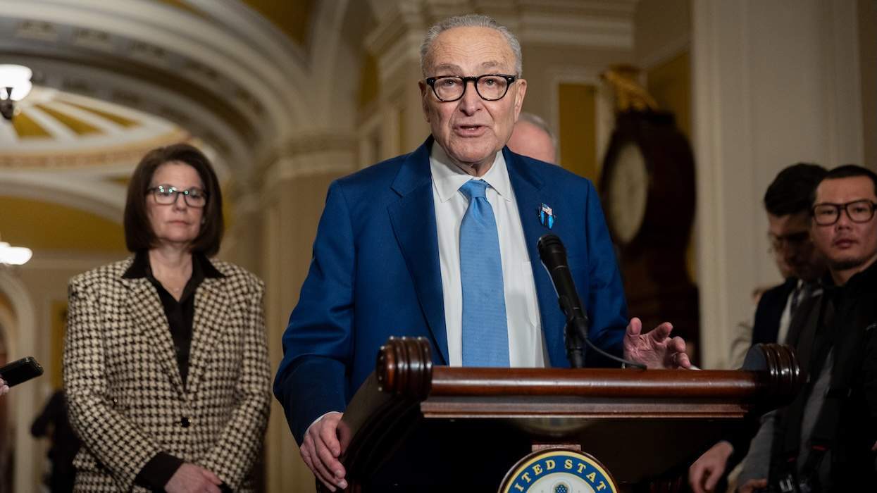 Sen. Chuck Schumer with several people around him at a podium speaking