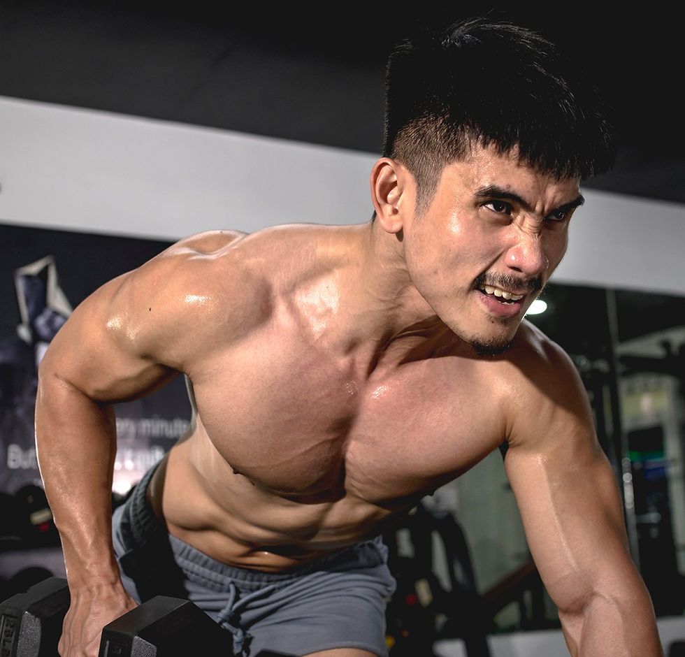 serious muscle man lifting weights at the gym