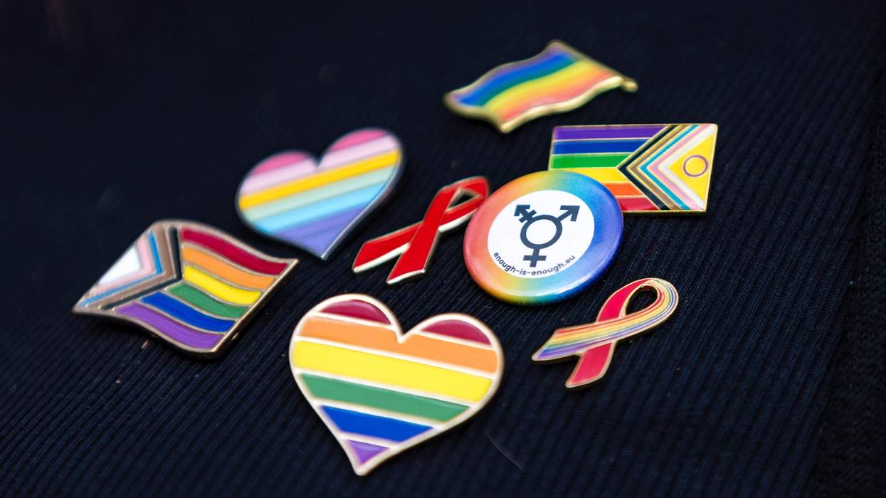 Several rainbow pins adorn a black cloth