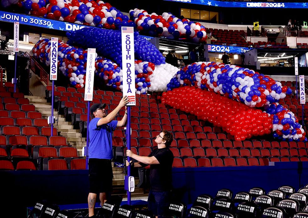Signs marking state seating sections are installed and adjusted ahead of the Democratic National Convention 2024 Chicago Illinois